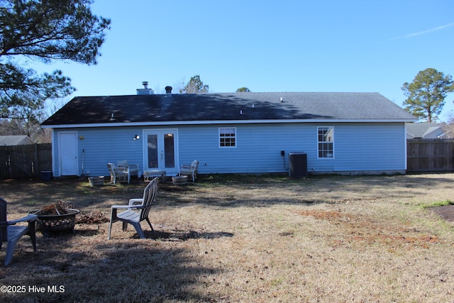 back of house with french doors, a yard, cooling unit, and a fire pit