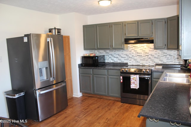 kitchen featuring backsplash, hardwood / wood-style flooring, sink, and appliances with stainless steel finishes