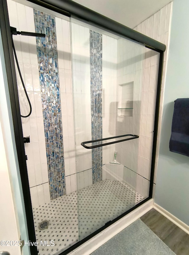 bathroom featuring wood-type flooring and a shower with door