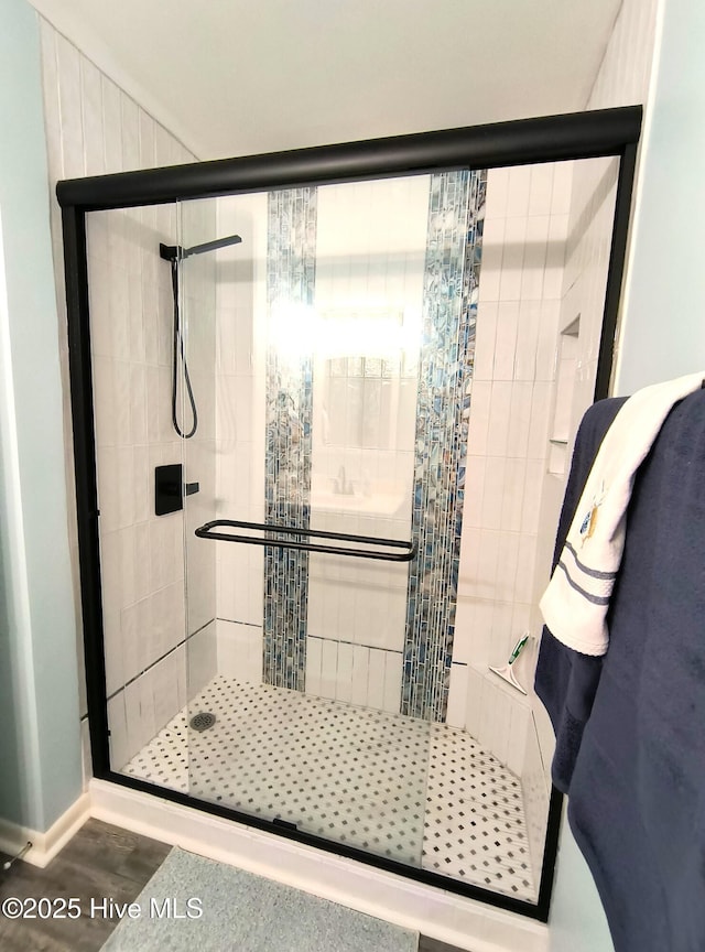 bathroom featuring hardwood / wood-style flooring and a shower with shower door