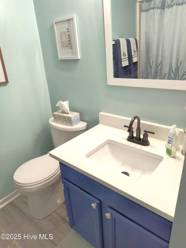 bathroom featuring vanity, hardwood / wood-style floors, and toilet