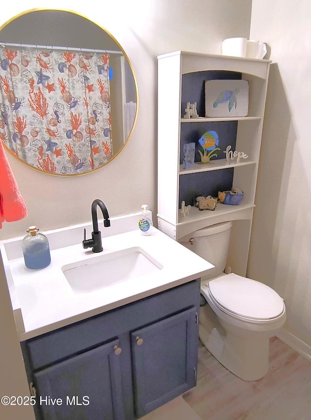 bathroom with hardwood / wood-style flooring, vanity, and toilet