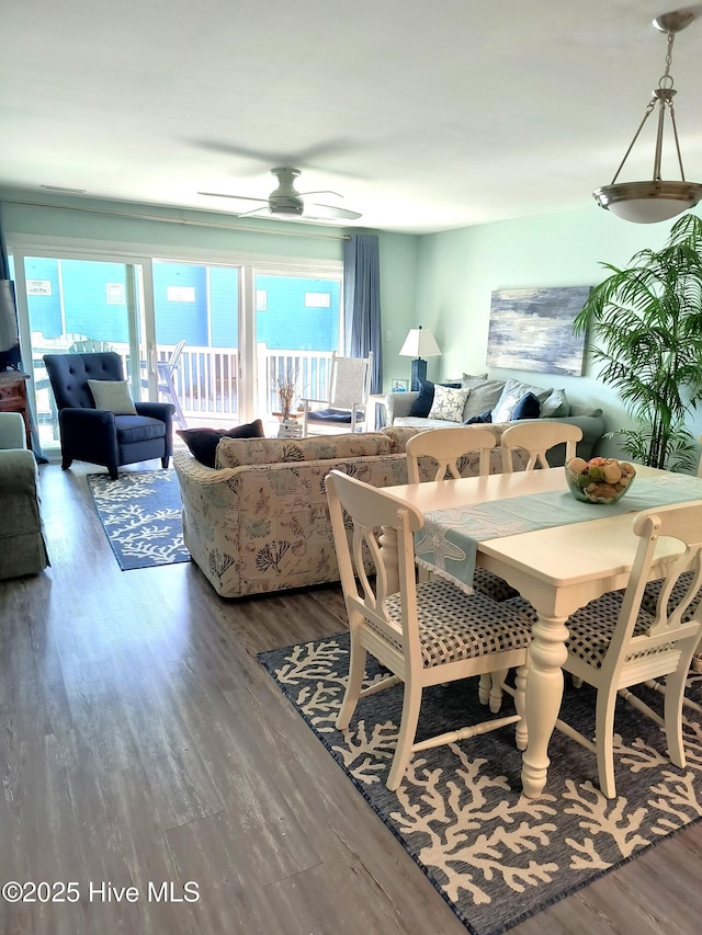 dining area with a water view, ceiling fan, and wood-type flooring