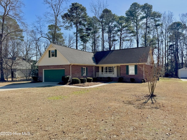 view of front of property featuring a garage, covered porch, and a front yard