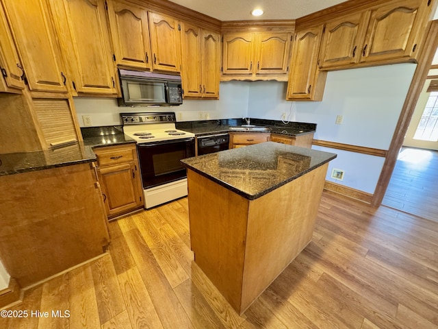 kitchen with dark stone countertops, sink, light hardwood / wood-style floors, and black appliances