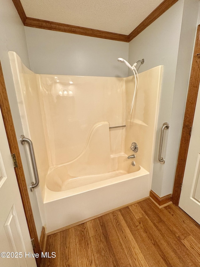 bathroom with ornamental molding, wood-type flooring, and a textured ceiling