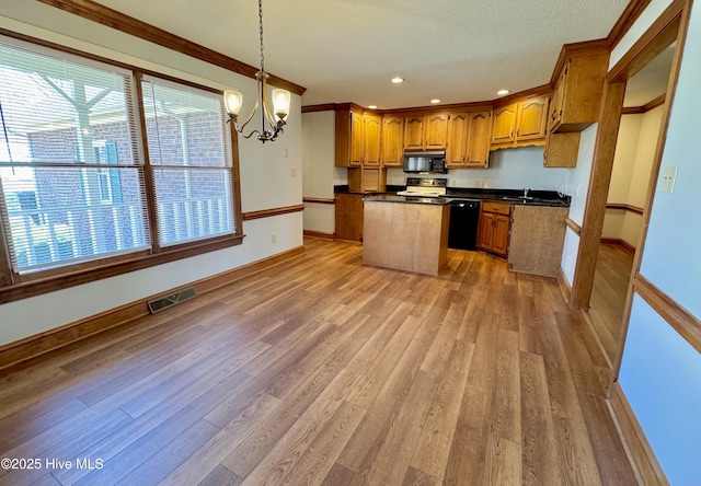 kitchen with a kitchen island, light hardwood / wood-style flooring, pendant lighting, and black appliances