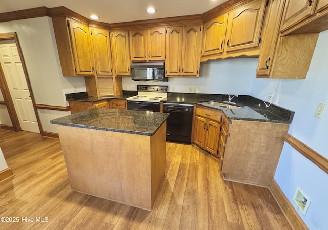 kitchen with dark stone countertops, sink, black appliances, and a kitchen island