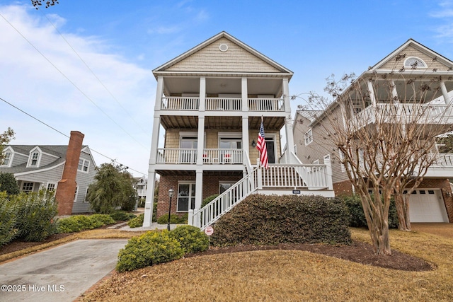 coastal inspired home featuring a balcony, a garage, and covered porch