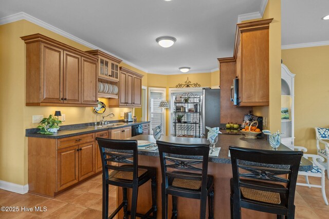 kitchen with sink, light tile patterned floors, a breakfast bar area, dishwasher, and ornamental molding