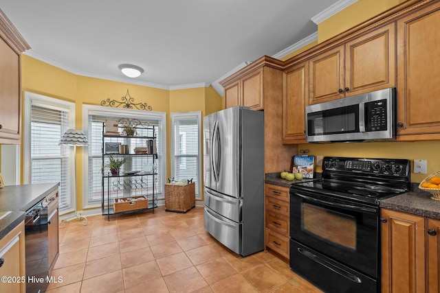 kitchen with crown molding, light tile patterned flooring, dark stone counters, and black appliances