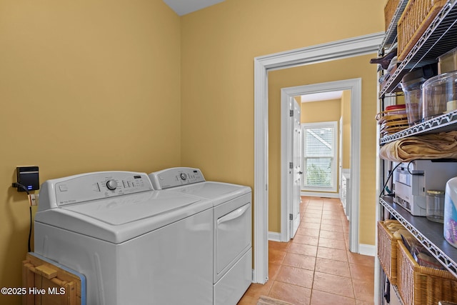 laundry room with washer and dryer and light tile patterned floors