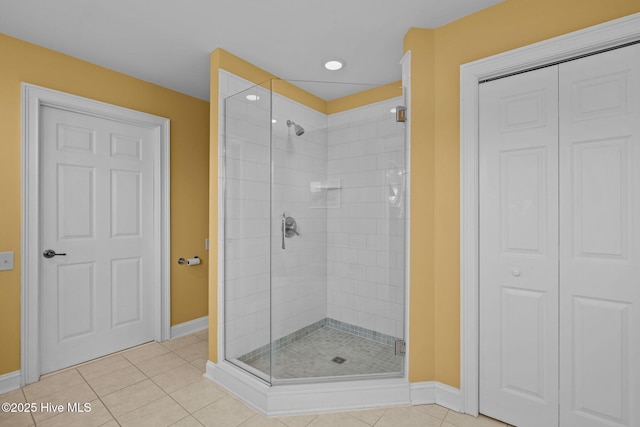 bathroom with a shower with door and tile patterned flooring