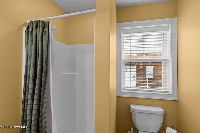 bathroom featuring toilet and a shower with shower curtain