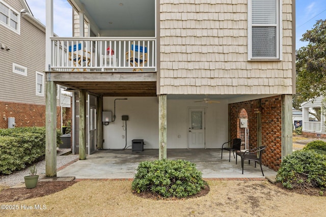 rear view of property with a balcony, ceiling fan, and a patio area