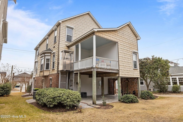 back of property with central AC unit, a yard, and a balcony