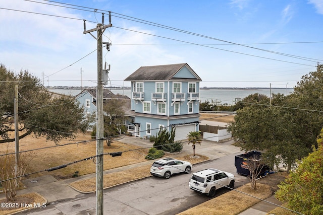 view of front of property featuring a garage and a water view