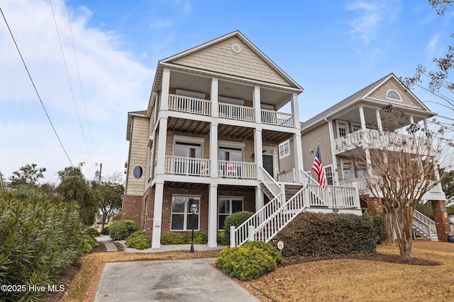 2208 Evans St, Morehead City, NC 28557 - view of front of house featuring a balcony, stairway, and covered porch