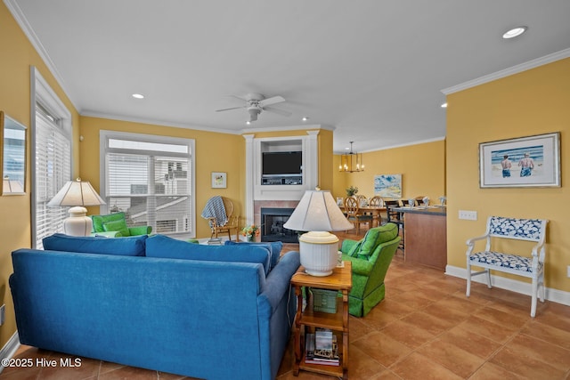 living room with tile patterned floors, ceiling fan with notable chandelier, and ornamental molding