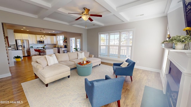 living room with coffered ceiling, light hardwood / wood-style floors, and beam ceiling