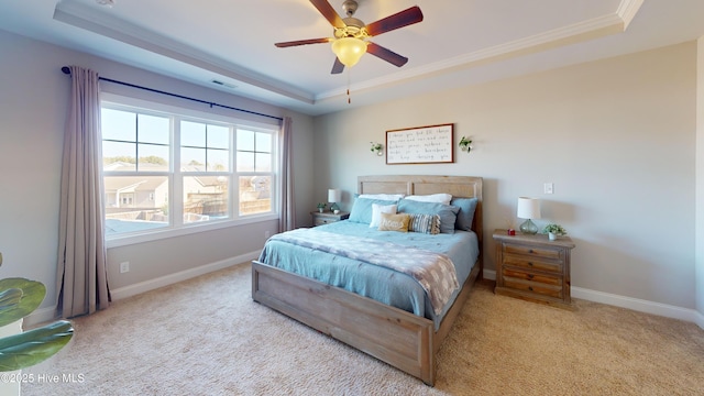 bedroom featuring light colored carpet, ornamental molding, and a tray ceiling