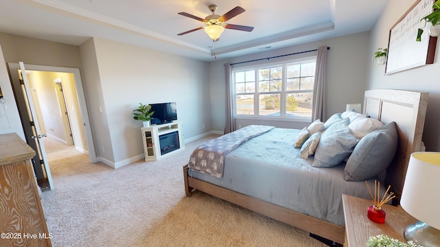 carpeted bedroom featuring crown molding, ceiling fan, and a tray ceiling