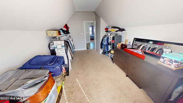 walk in closet featuring lofted ceiling and light carpet