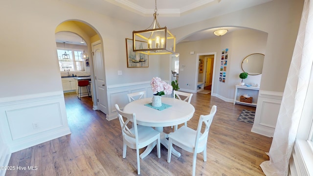 dining room featuring sink, crown molding, light hardwood / wood-style flooring, and a chandelier