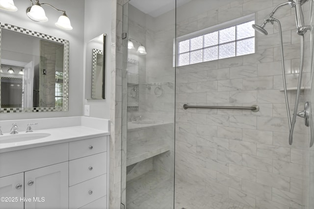 bathroom with a tile shower and vanity