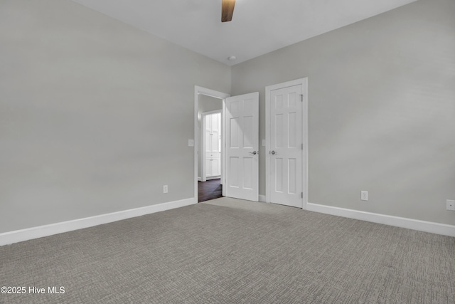 carpeted spare room featuring ceiling fan