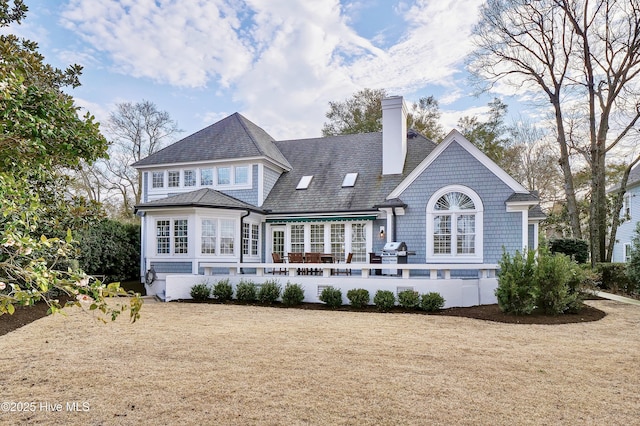 rear view of property featuring a lawn