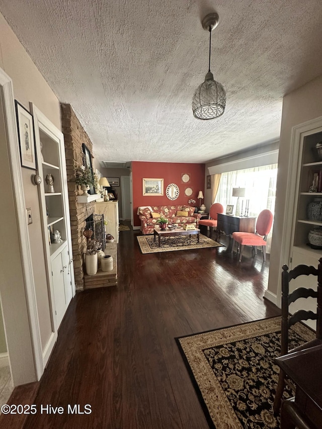 interior space with dark wood-type flooring, a fireplace, and a textured ceiling