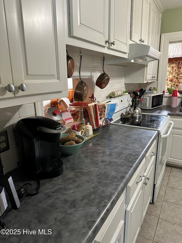 kitchen featuring tasteful backsplash, white cabinetry, and white electric range oven