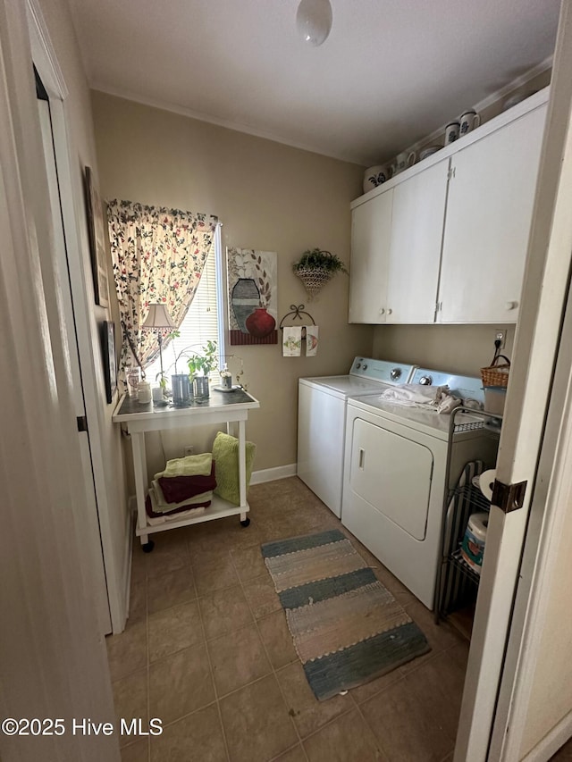 laundry room featuring cabinets, washer and clothes dryer, and dark tile patterned flooring