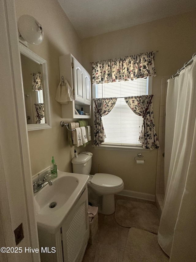 bathroom featuring walk in shower, vanity, tile patterned floors, and toilet