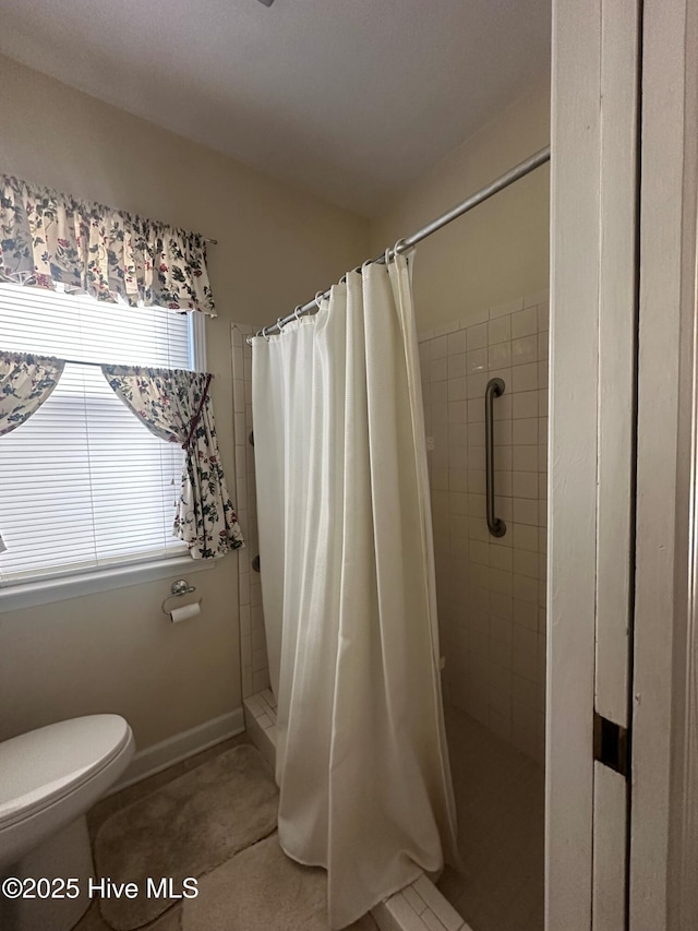 bathroom with a shower with curtain and toilet