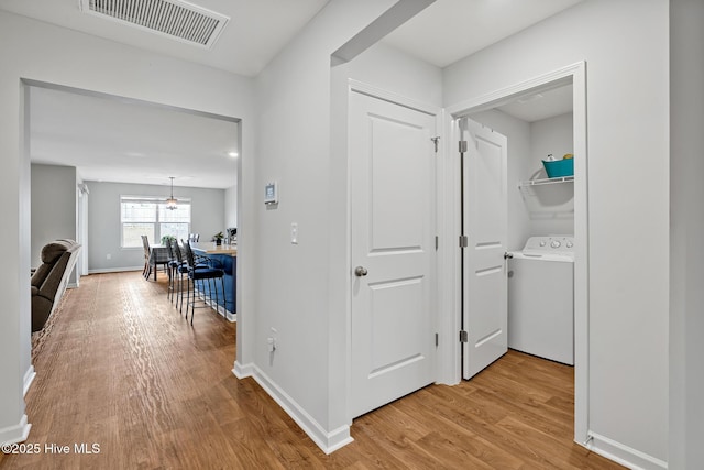 hallway featuring washer / clothes dryer and light hardwood / wood-style floors