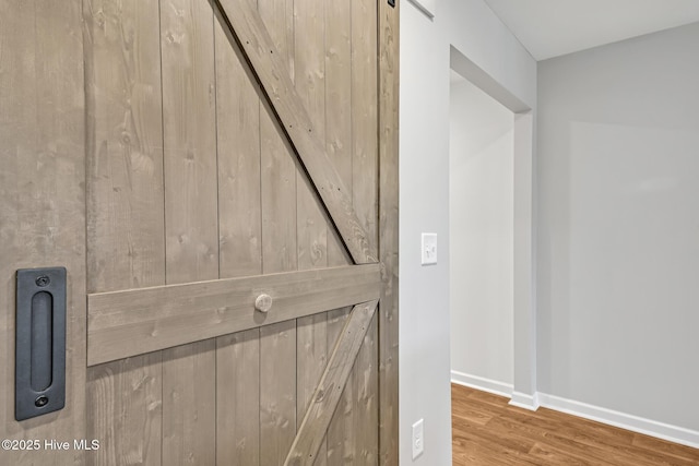 interior details featuring hardwood / wood-style flooring and a barn door