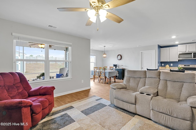 living room featuring ceiling fan and light wood-type flooring