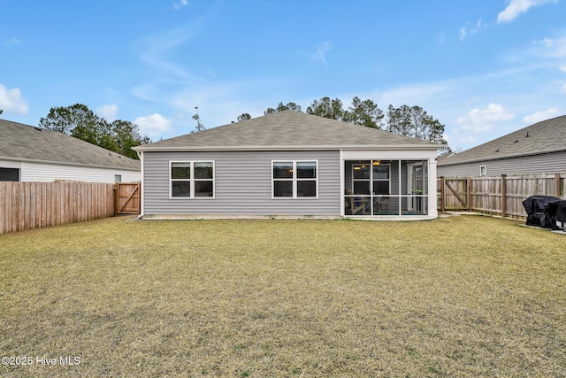 rear view of house with a yard and a sunroom