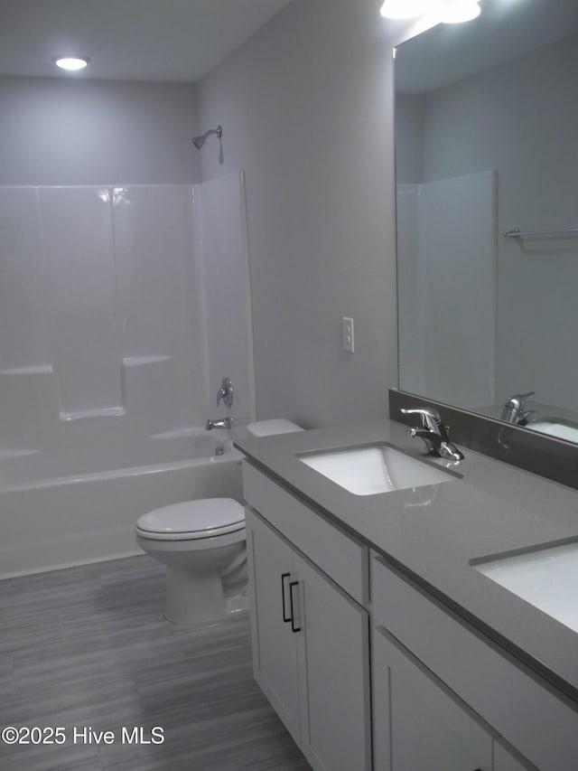 bathroom featuring vanity, shower / bathing tub combination, and toilet