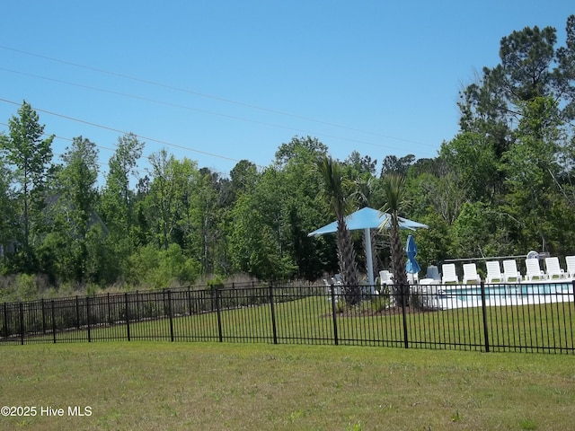 view of jungle gym with a lawn, a community pool, and fence