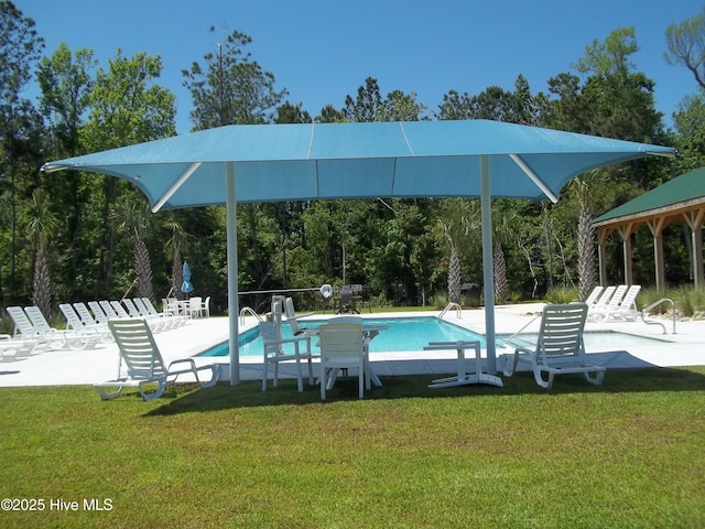 community pool featuring a yard and a patio area