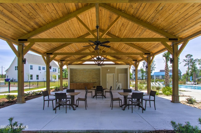 view of patio / terrace with fence, a gazebo, outdoor dining area, a fenced in pool, and ceiling fan