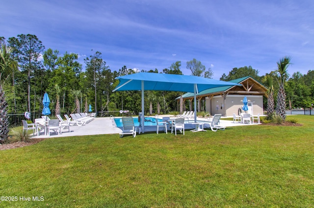 pool with a patio area and a lawn