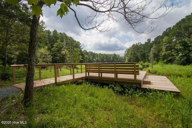 view of property's community featuring a wooded view and a wooden deck