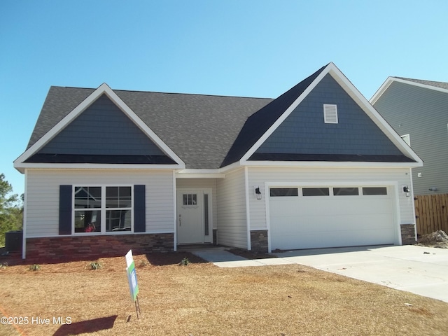 craftsman-style home with concrete driveway, a garage, and stone siding