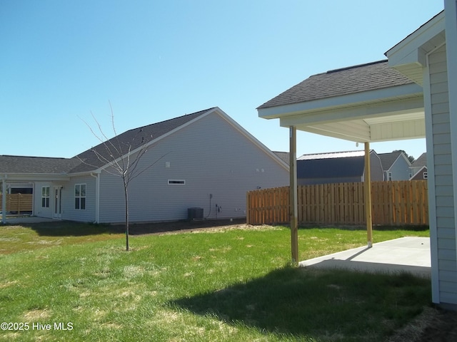 view of yard with central air condition unit, a patio, and fence