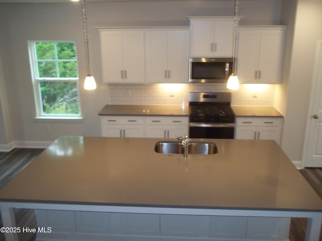 kitchen featuring a sink, white cabinets, a spacious island, and stainless steel appliances