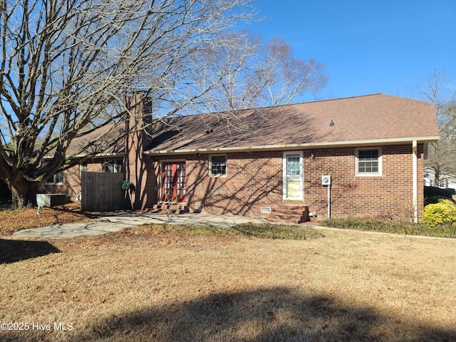 rear view of house featuring a patio and a lawn